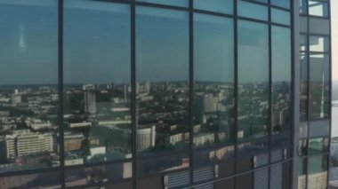 Şehir panoramasının arka planında yüksek katlı iş yerlerindeki ofislerin en iyi manzarası. Stok görüntüleri. Şehrin yansıması güneşli manzaranın arka planında iş gökdeleninin pencerelerinde