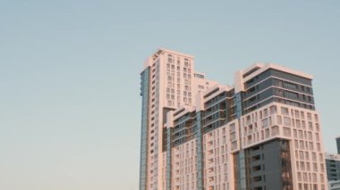 Mavi gökyüzünün arka planındaki evlerin güzel modern mimarisi. Stok görüntüleri. Gün batımında beyaz apartmanın arka planında güzel sokak ışıkları