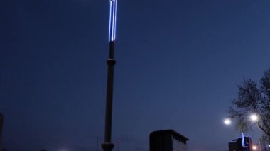 Neonlu modern şehir fenerleri. Stok görüntüleri. Neon detaylarla modern kentsel ışıklandırma tasarımının alt görüntüsü. Şehir otoyollarındaki çifte ışıklar akşam gökyüzünde parlıyor