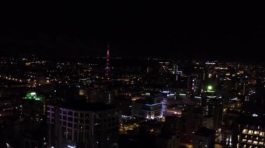 Havai fişeklerle dolu gece şehrinin en iyi manzarası. Stok görüntüleri. Çok renkli havai fişeklerin parladığı karanlık şehir. Gece Kenti Panoraması Havai fişeklerle tatilde