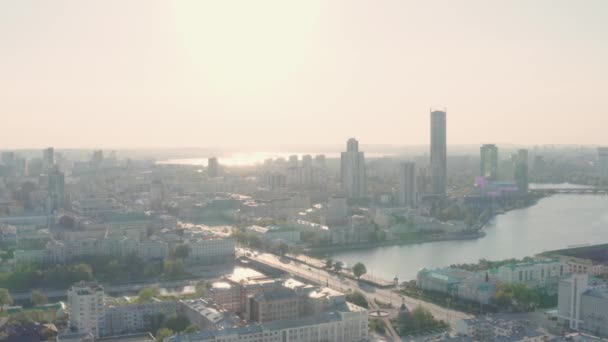 Panorama słonecznego nowoczesnego miasta z rzekami i jeziorami. Materiał filmowy. Górny widok na nowoczesne miasto z wieżowców i jezior w obszarze odzwierciedlającym jasne słońce. Nowoczesne miasto przyjazne dla środowiska — Wideo stockowe
