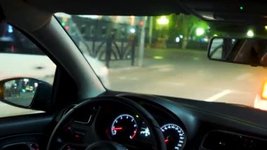Gece şehrinden geçen hızlı araba. Stok görüntüleri. Gece vakti şehrin etrafında ışıklarla birlikte araba sürme zamanı. Gece şehrinde hızlı giden bir adamın yakın çekimi.