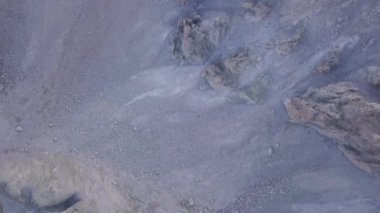 Kayalık taş arazinin en üst manzarası. Şarjör. Dağların yüksek kesimlerinde yaşayan cansız toprağın dokusu. Bitkisiz gri bölge ve taşlarla kaplı.