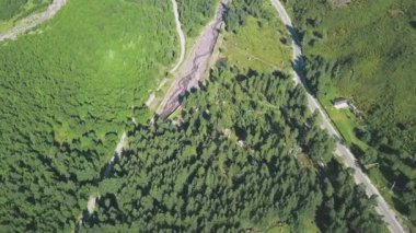 Yeşil ormandan geçen dağ yolunun üst manzarası. Şarjör. Yeşillik ve dağlara giden ağaçların arasından muhteşem bir yol manzarası. Dağlara yaz gezisi