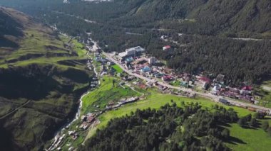 Dağ vadisindeki modern kasabanın en iyi manzarası. Şarjör. Dağların arasında gelişmekte olan bir kasaba. Dağlık bölgede yaz yeşiliyle çevrili bir şehir.
