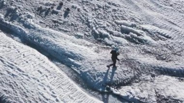 Karlı dağlarda dinlenen dağcı manzarası. Şarjör. Aktif gezgin karlı dağlarda dinlenir. Dağlarda güneşli bir günde dinlenen dağcılar için muhteşem bir manzara.