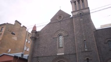 Şehirdeki Katolik Kilisesi 'nin koyu tuğlalı mimarisi. Başla. Karanlık görünümlü eski Katolik Kilisesi. Dini cazibe ve mimari. Lourdes Katolik Kilisesi 'nin leydisi.