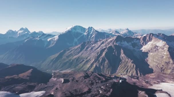 Panorama de montaña con nieve y picos rocosos sobre fondo cielo azul. Clip. Cordilleras extremadamente hermosas cubiertas de nieve en un claro día soleado — Vídeos de Stock