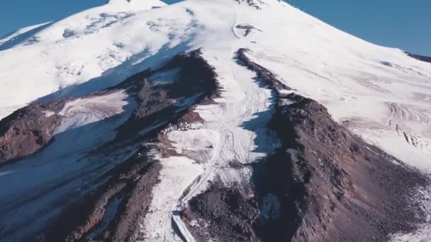 Гірський хребет з засніженим піком на фоні блакитного неба. Кліп. Снігова стежка веде до вершини гірського льоду в чистий день. Вид на засніжену гору — стокове відео