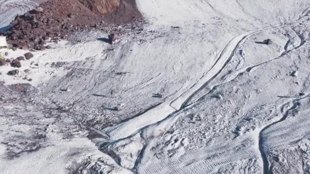 Vue de dessus de la marche touristique dans les montagnes enneigées. Clip. Escalade le long des pentes enneigées de montagne massive par une journée ensoleillée. Loisirs actifs dans les montagnes enneigées — Video