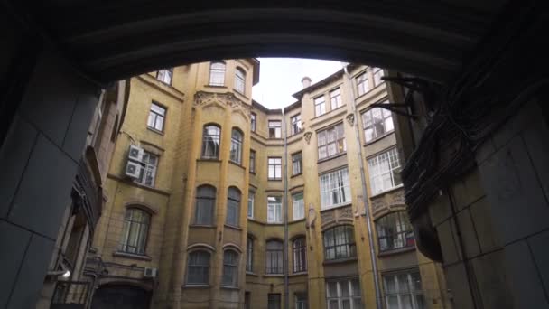 Fechado em volta do pátio da velha casa. Acção. Pátio bem com arquitetura antiga com detalhes e grandes janelas. Os pátios fechados habituais de São Petersburgo são o marco da cidade — Vídeo de Stock