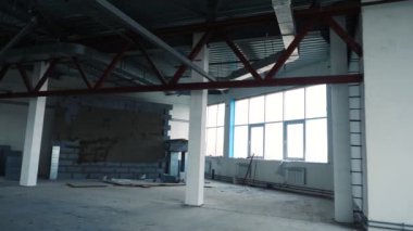 Büyük pencereli boş odada tamirat. Stok görüntüleri. Çelik kirişleri ve geniş pencereleri olan yeni boş odada tadilat. White ofislerin ya da depoların altına yerleştiriliyor