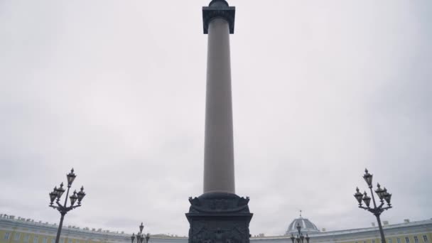 Alexandrijnse zuil in Sint Petersburg. Actie. Onderaanzicht van architectonisch monument in de vorm van pilaar met engelenkruis op de top. Alexander kolom op achtergrond bewolkte lucht — Stockvideo