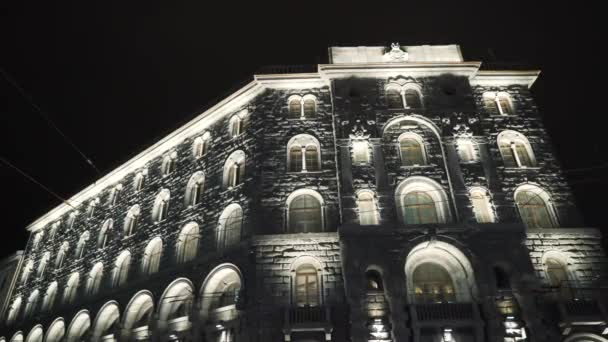 Helle Beleuchtung der Fenster des historischen Gebäudes. Handeln. Untere Ansicht des historischen Steingebäudes mit weißer Beleuchtung am Nachthimmel