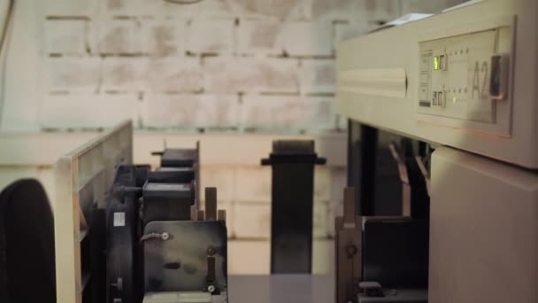 Υπάλληλος γραφείου που εργάζεται σε εκτυπωτικά μηχανήματα. Στικ. Κοντινό πλάνο ενός υπαλλήλου γραφείου που βάζει χαρτί στη γραφομηχανή. Μεγάλη ποσότητα χαρτιού τοποθετείται στη μηχανή εκτύπωσης — Αρχείο Βίντεο