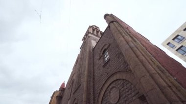 Kırmızı tuğlalı Katolik Kilisesi 'nin alt manzarası. Başla. Eski kilise modernist tarzda arka planda bulutlu bir gökyüzünde duruyor. St. Petersburg şehrinin tarihi simgesi.