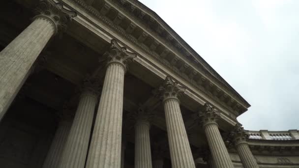 Untere Ansicht der antiken Säulen mit korinthischen Ordnungen. Handeln. Mächtige Säulen vor wolkenverhangenem Himmel. Altbau mit Laubengang — Stockvideo