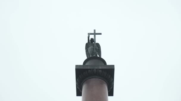 Pilastro con angelo che tiene croce. Azione. Vista in basso su colonna Alexander su sfondo di cielo nuvoloso. Colonna Angelo di Alessandro. Angelo scultura su piedistallo cilindrico — Video Stock