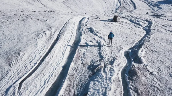 Vista dall'alto delle passeggiate turistiche in montagna innevate. Clip. Scalatore passeggiate lungo pendii innevati di montagna massiccia nella giornata di sole. Ricreazione attiva in montagne innevate — Foto Stock