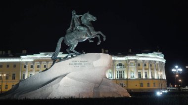 İmparator 'un geceleyin at üstünde olduğu tarihi anıt. Başla. Rus İmparatoru anıtı, tarihi binanın arka planında gece aydınlatmalı taşın üzerinde duruyor. Bronz atlı