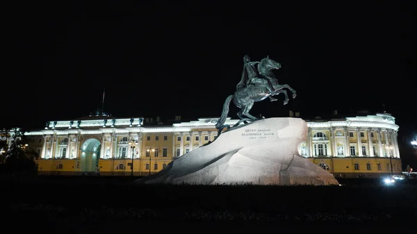 Monument historique avec Empereur à cheval la nuit. L'action. Monument à l'empereur russe se dresse sur la pierre sur fond de bâtiment historique avec éclairage nocturne. Cavalier en bronze — Photo