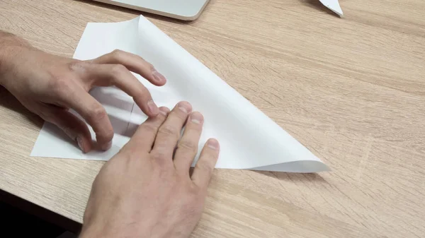 Primo piano di uomo carta origami pieghevole. Filmati delle scorte. Le mani degli uomini sono piegate da origami di carta bianca o aeroplano. Classe Origami durante la pausa al lavoro — Foto Stock