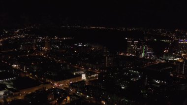 Karanlık gökyüzü arka planında şehir ışıkları olan panoramik manzara. Stok görüntüleri. Uçak penceresinden güzel ışıkları ve gece hayatı konsepti olan büyük bir şehrin manzarası..