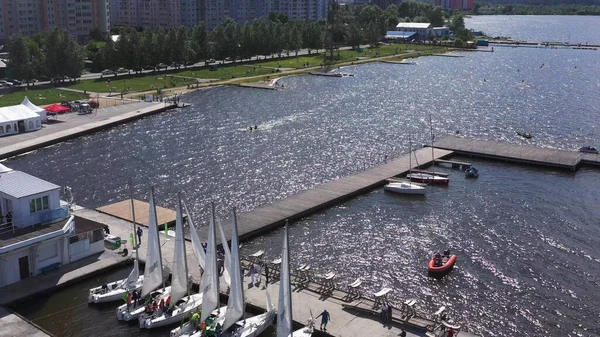 People Kayaking on city river near moored white small yachts. Video. Aerial view of sports training in kayaking and canoeing near the pier, concept of sport and active lifestyle. — Stock Photo, Image