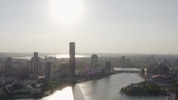 Vista aérea da cidade de Ekaterinburg com um rio Iset e edifícios altos, Rússia. Imagens de stock. Voando sobre a cidade no fundo do céu por do sol, conceito de arquitetura. — Vídeo de Stock