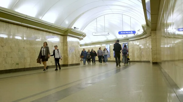 Russland - Sankt Petersburg, Juni 2020: Russland - Sankt Petersburg, Juni 2020: Menschen, die in U-Bahn-Stationen gehen, Konzept des öffentlichen Verkehrs. Medien. Menschenmenge läuft durch den langen Korridor — Stockfoto