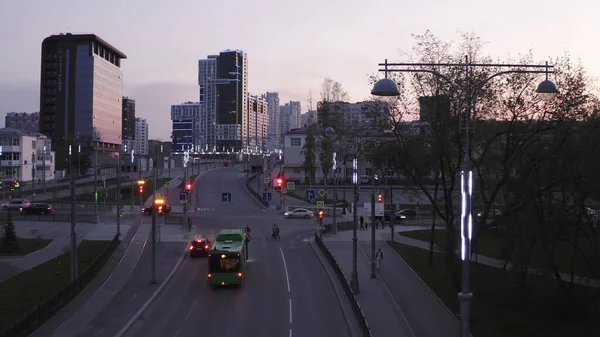 Veduta aerea della città al tramonto, con incrocio e semaforo. Filmati delle scorte. Sera in una città moderna con grattacieli decorati da vetrate e lampade luminose. — Foto Stock