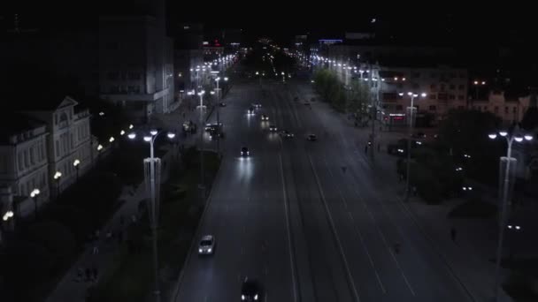 Vista aérea do tráfego noturno na estrada larga ao longo da rua grande da cidade. Imagens de stock. Bela avenida à noite com carros de condução, lanternas e edifícios históricos. — Vídeo de Stock
