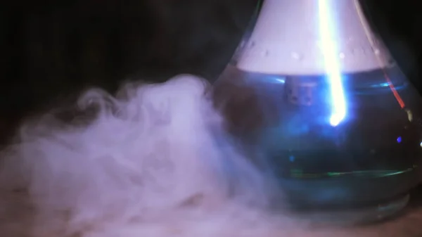 Baňka Hookah s modrou vodou zakrytou kouřem. Média. Detailní záběr průhledné skleněné mísy pro kouření shisha stojící na stole, koncept špatných návyků. — Stock fotografie