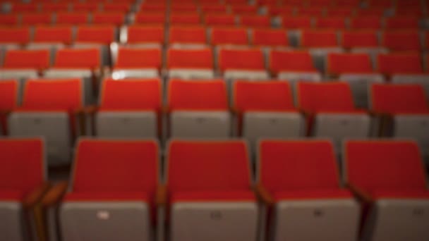 Fileiras vazias de assentos de cinema. Mídia. Vista turva de assentos vazios vermelhos na sala de cinema. Cinemas vazios devido a pandemia de coronavírus — Vídeo de Stock