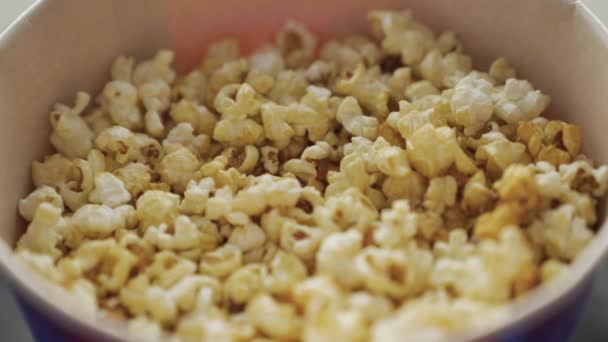 Close-up de pipocas doces em balde. Mídia. Pipocas doces deliciosas para assistir filmes no cinema. Um lanche doce no cinema. Pipocas tradicionais no cinema — Vídeo de Stock