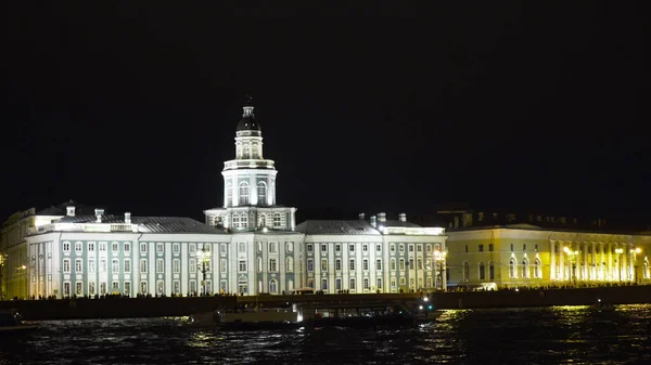 Φωτισμός παλαιού κτιρίου κοντά σε ανάχωμα με βάρκες τη νύχτα. Πάμε. Φωτισμένο κτίριο της Kunstkamera στην Αγία Πετρούπολη τη νύχτα — Φωτογραφία Αρχείου