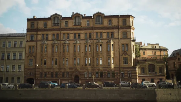 Bella vecchia architettura in stile mattone modernista. Acido. Storico edificio in mattoni situato sul fiume della città con persone a piedi. Architetto Schroeters casa su argine Moika — Foto Stock