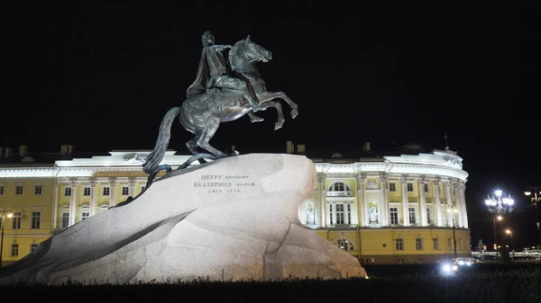 Monument illuminé de cavalier en cuivre la nuit. L'action. Grand monument à l'empereur à cheval debout sur la pierre. Point de repère célèbre de Saint-Pétersbourg la nuit — Photo