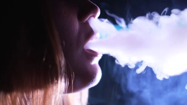 Nachtleven concept, mooie jonge vrouw profiel roken hookah. De media. Close-up zijaanzicht van een meisje gezicht dampen in nachtclub, uitademen rook op het feest. — Stockfoto