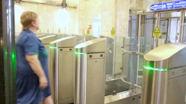 İnsanlar metro istasyonunda atomatik kapılardan geçiyorlar. Medya. Birçok geçiş kapısı metro istasyonuna girmek veya çıkmak için, toplu taşıma kavramı.