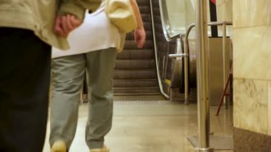 Metro istasyonu ve yürüyen merdiven inip çıkıyor. Medya. İnsanlar metro istasyonunun mekanik merdivenlerine doğru yürüyorlar, toplu taşıma kavramı.