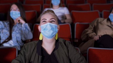 Maskeli insanlar komik filmler izler. Medya. Tıp maskeli insanlar sinemada oturup film izlerken gülerler. Salgın sırasında sinemaların açılması