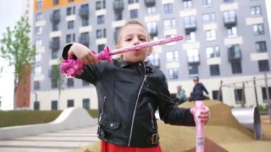 Mutlu çocuk, sonbaharın başında oyun sahasında sabun köpüğüyle oynuyor. Başla. Çocukluk ve kiralama kavramı, sokaklarda eğlenmek..