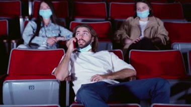 Adam telefonda konuşuyor ve sinemadaki insanları rahatsız ediyor. Medya. Genç bir kadın sinemada film izlerken diğer adamın cep telefonuyla konuşmasını engellemek istiyor..