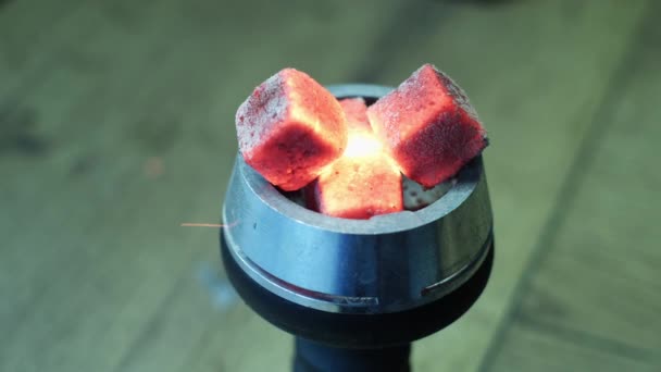 Close up of hookah red hot coal, process of hookah preparation. Média. Foukání na horké hookah uhlí s letícími jiskry na rozmazaném pozadí. — Stock video