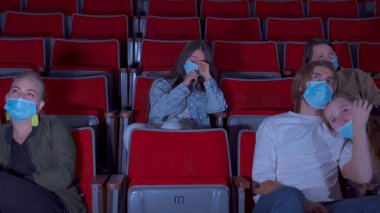 Seyirciler sinemada tiyatro filmi izliyor. Medya. Grup aktivitesi ve eğlence konsepti, sinemada hüzünlü bir film izlerken erkek arkadaşının omzunda ağlayan kadın..