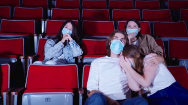 Seyirciler sinemada tiyatro filmi izliyor. Medya. Grup aktivitesi ve eğlence konsepti, sinemada hüzünlü bir film izlerken erkek arkadaşının omzunda ağlayan kadın..