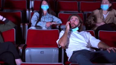 Adam telefonda konuşuyor ve sinemadaki insanları rahatsız ediyor. Medya. Genç bir kadın sinemada film izlerken diğer adamın cep telefonuyla konuşmasını engellemek istiyor..