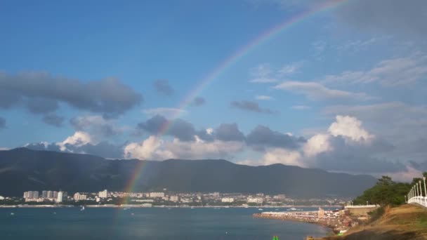 Vue imprenable sur l'arc-en-ciel touche la mer sous la pluie dans une petite ville de la mer Noire. Concept. Paysage marin d'été sur fond bleu ciel nuageux. — Video