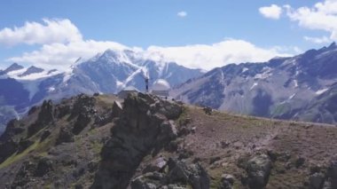 Elbrus Dağı 'nın havadan görünüşü, hava manzarası. Şarjör. Tepelerde yürüyen, karlı tepeleri olan dev dağlarla çevrili insanların inanılmaz manzarası, seyahat kavramı..